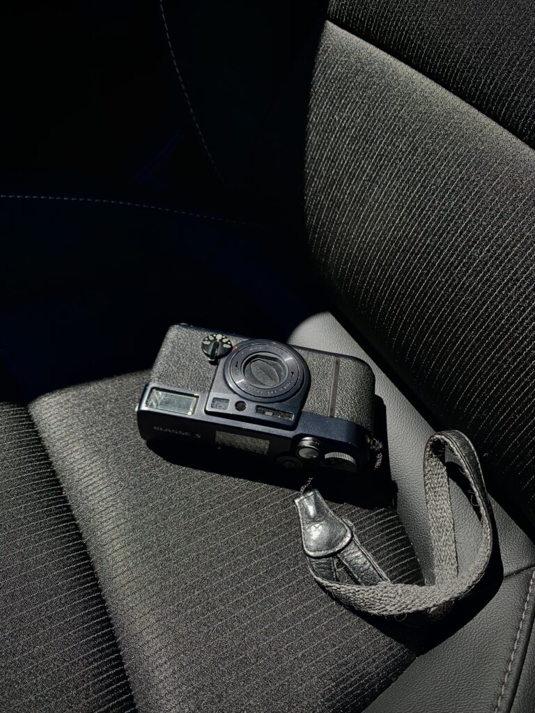 A Fuji Klasse S compact camera resting on a car seat. 